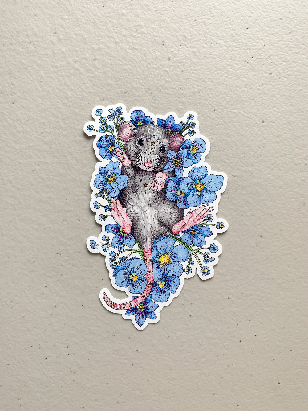 Autocollant souris dans un lit de fleurs